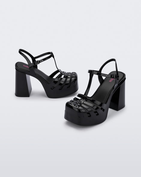 An angled side view of a pair of black Melissa Party Heels with several straps and a closed toe front.