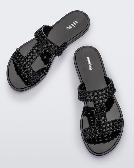 Top view of a pair of black Melissa Glowing slide with black gem stones on the straps and a black sole.