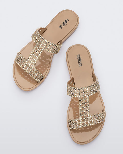 Top view of a beige / gold Melissa Glowing slide with gold gem stones on the straps and a beige sole.