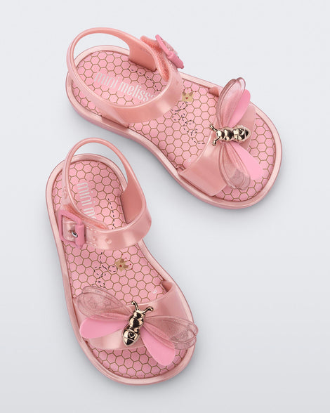 Top view of a pair of pink Mini Melissa Mar Bugs sandals with a gold bug with wings on them.