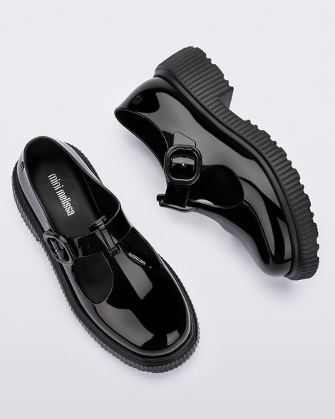 Top and side view of a pair of black Mini Melissa Jackie loafers with two cut outs and a buckle detail strap.