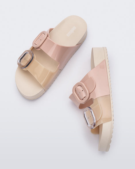 Top and side view of a pair of Beige/Pink Melissa Cozy slides with two pink and beige straps with a buckle detail.