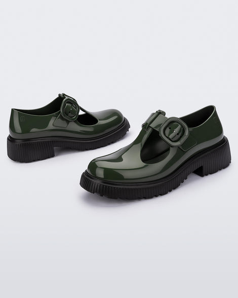 A side view of a pair of Green Mini Melissa Jackie loafers with a green base, two cut outs, a green buckle detail strap and black sole.