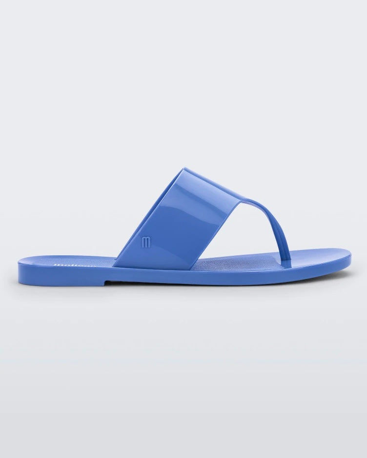 Side view of a Melissa Essential Chic flip flop in Opaque Blue with thick thong strap