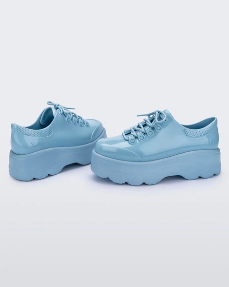 Side view of a pair of blue platform Melissa Kick Off Sneakers with laces.