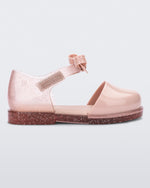 Side view of a pink Mini Melissa Amy sandal with a pink closed toe section and a back pink glitter strap with a lace like bow detail.