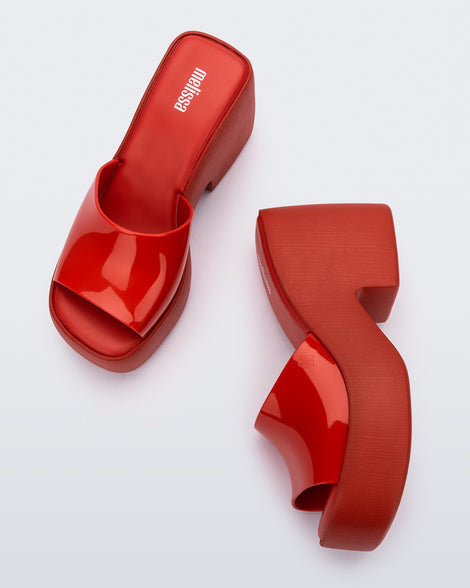 Top view and side view of a pair of Melissa Posh platform slides in Red