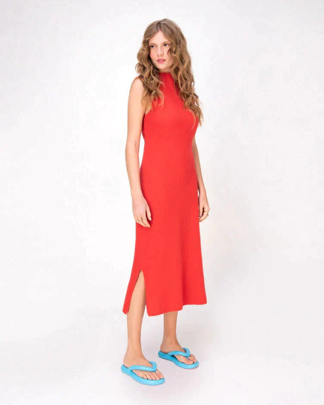 A model posing for a picture in a red dress wearing a pair of sky blue Melissa Free Flip Flops with puffer-like straps.