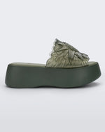 Side view of a green Melissa Panc Becky platform slide with a flower on top.