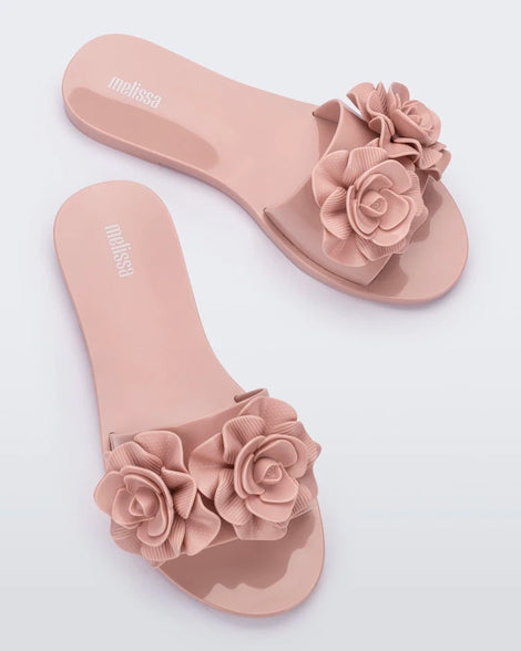 Top view of a pair of light pink Melissa Babe Garden slides with two flowers on the front strap.