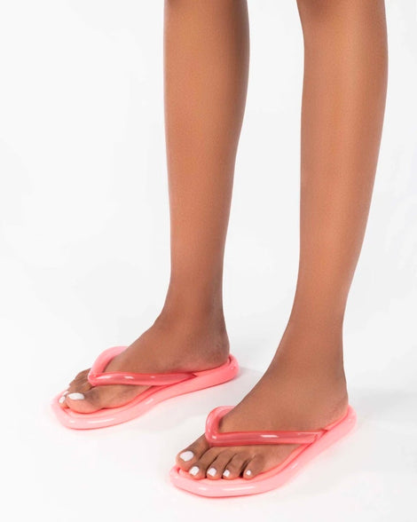 A model's legs wearing pink Melissa Airbubble Flip Flops.