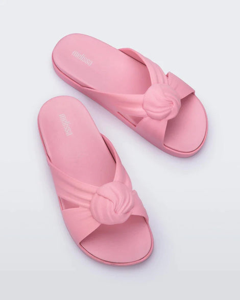 Top view of a pair of pink Melissa Plush slides with a twist front detail.