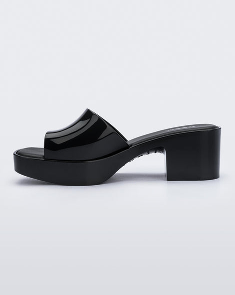 Inner side view of Melissa Shape slide in black, with a platform heel. 