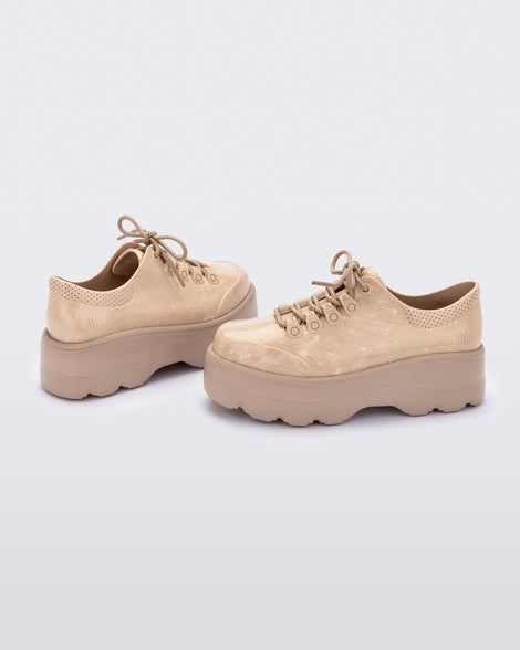 An angled side view of a pair of beige platform Melissa Kick Off Sneakers with laces.