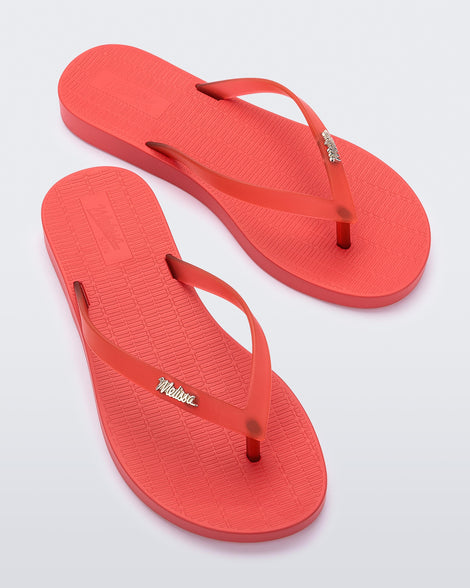 Top view of a pair of red Melissa Sun Venice flip flops with a 