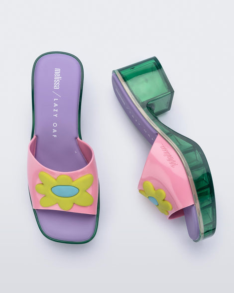 Top and side view of a pair of Melissa Shape slides with green platform heel,  a pink wide front strap with a yellow and blue flower on the top of the strap and a purple insole