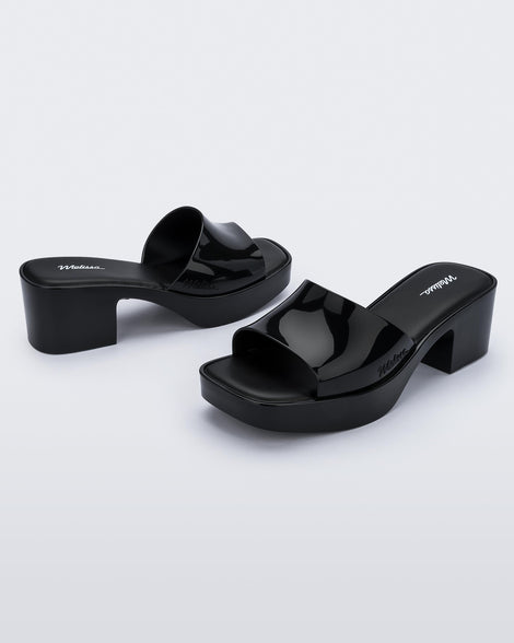 Front and back view of a pair of Melissa Shape slides in Black with a platform heel