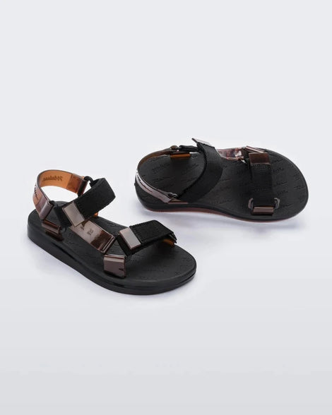 Angled view of a pair of black Melissa Papete sandals with black and transparent brown straps.