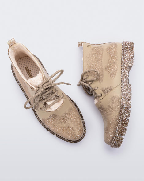 A top and side view of a pair of Beige Flecked/Glitter Melissa Fluffy Boots with laces and a rubber sole.