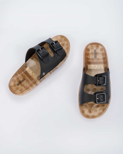 Top view of a pair of Melissa Wide Slide sandals with gold speckled sole and two black front straps