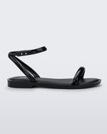 An outter side view of a black Melissa Wave Sandal with one front strap and one ankle strap.