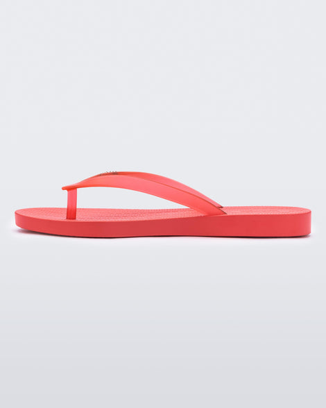 An inner side view of a red Melissa Sun Venice flip flop with a 